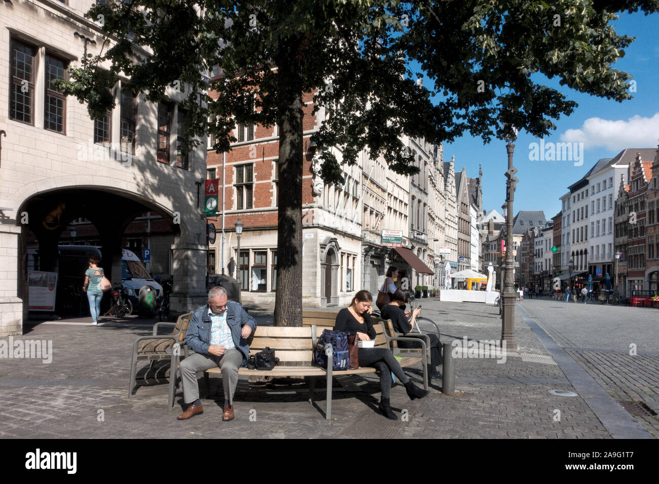 L uomo e la donna seduta su una panchina ane di mangiare il pranzo in città ​​center di Anversa, Belgio Foto Stock