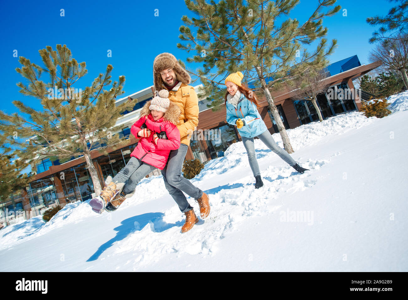 Vacanza invernale. Tempo per la famiglia insieme all'aperto uomo azienda ragazza ridere di filatura eccitato Foto Stock