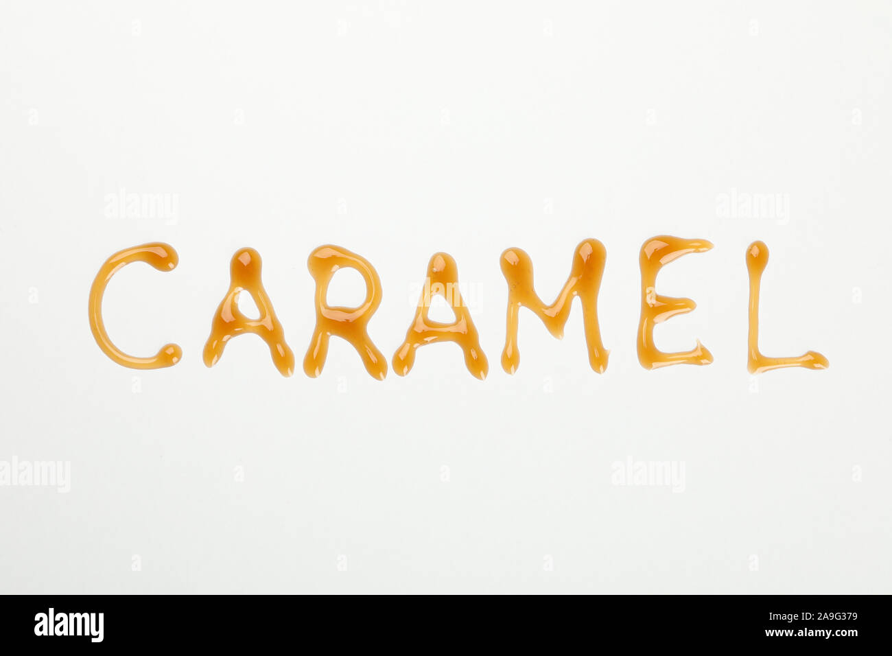 Iscrizione caramello su sfondo bianco, spazio per il testo Foto Stock