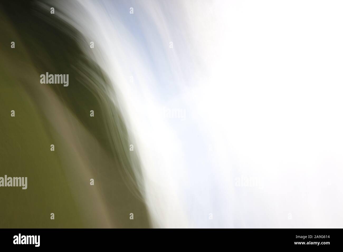 Immagine astratta che mostra striature sfocate di luce bianca o di colore contro sfumature di verde in background Foto Stock