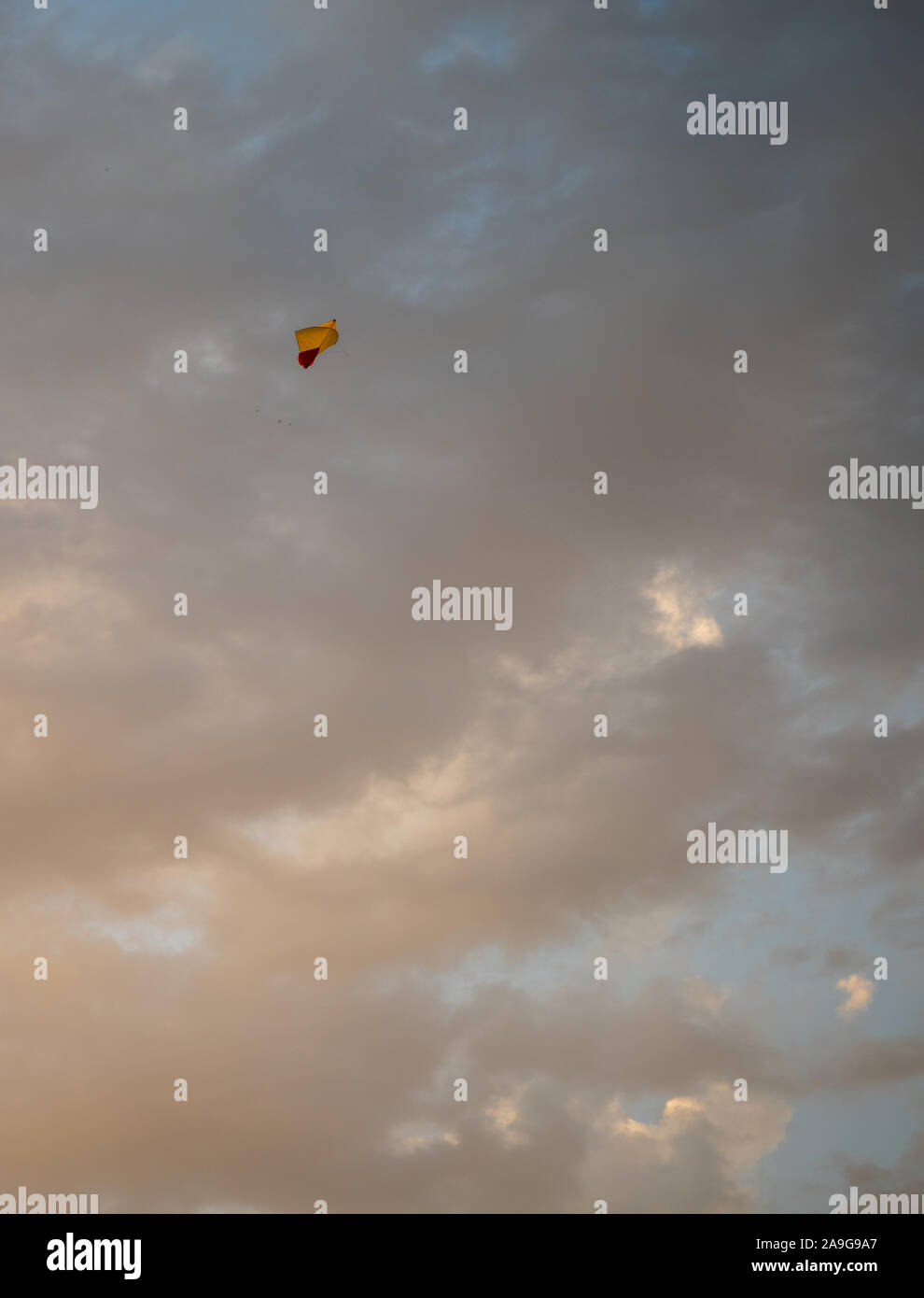 Aquilone giallo nel cielo contro dense nubi Foto Stock
