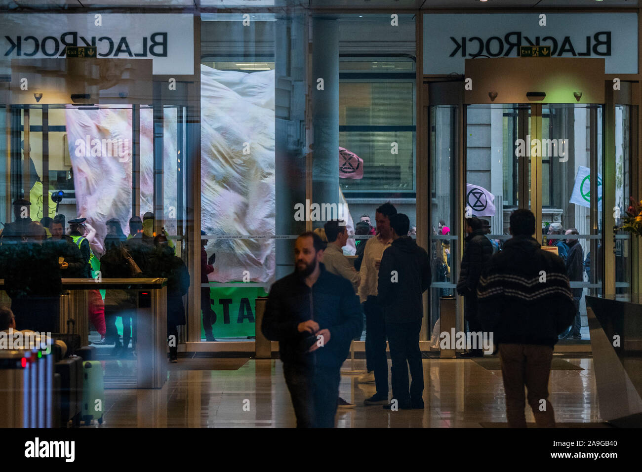 Londra, Regno Unito. 15 Nov 2019. Callong su Blackrock a "fuori il fuoco" - estinzione della ribellione UK si riuniscono di fronte all'impresa di investimento BlackRock per impegnarsi in una protesta nonviolenta alla sfida della ditta come " un giocatore principale' che guida la crisi climatica e la deforestazione in tutto il mondo. Dump di attivisti un mucchio di ceneri di legno nella parte anteriore di BlackRock di porte di ingresso. Il gruppo sta chiamando per lunga un anno BoycottForAmazonia, chiedendo la gente a smettere di acquistare prodotti legati alla deforestazione amazzonica e di violazioni dei diritti umani. Credito: Guy Bell/Alamy Live News Foto Stock