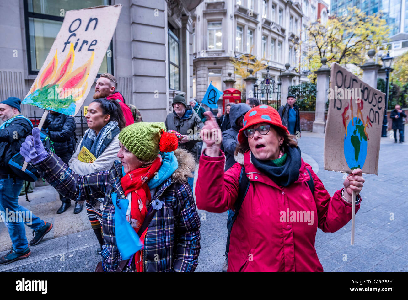 Londra, Regno Unito. 15 Nov 2019. Callong su Blackrock a "fuori il fuoco" - estinzione della ribellione UK si riuniscono di fronte all'impresa di investimento BlackRock per impegnarsi in una protesta nonviolenta alla sfida della ditta come " un giocatore principale' che guida la crisi climatica e la deforestazione in tutto il mondo. Dump di attivisti un mucchio di ceneri di legno nella parte anteriore di BlackRock di porte di ingresso. Il gruppo sta chiamando per lunga un anno BoycottForAmazonia, chiedendo la gente a smettere di acquistare prodotti legati alla deforestazione amazzonica e di violazioni dei diritti umani. Credito: Guy Bell/Alamy Live News Foto Stock