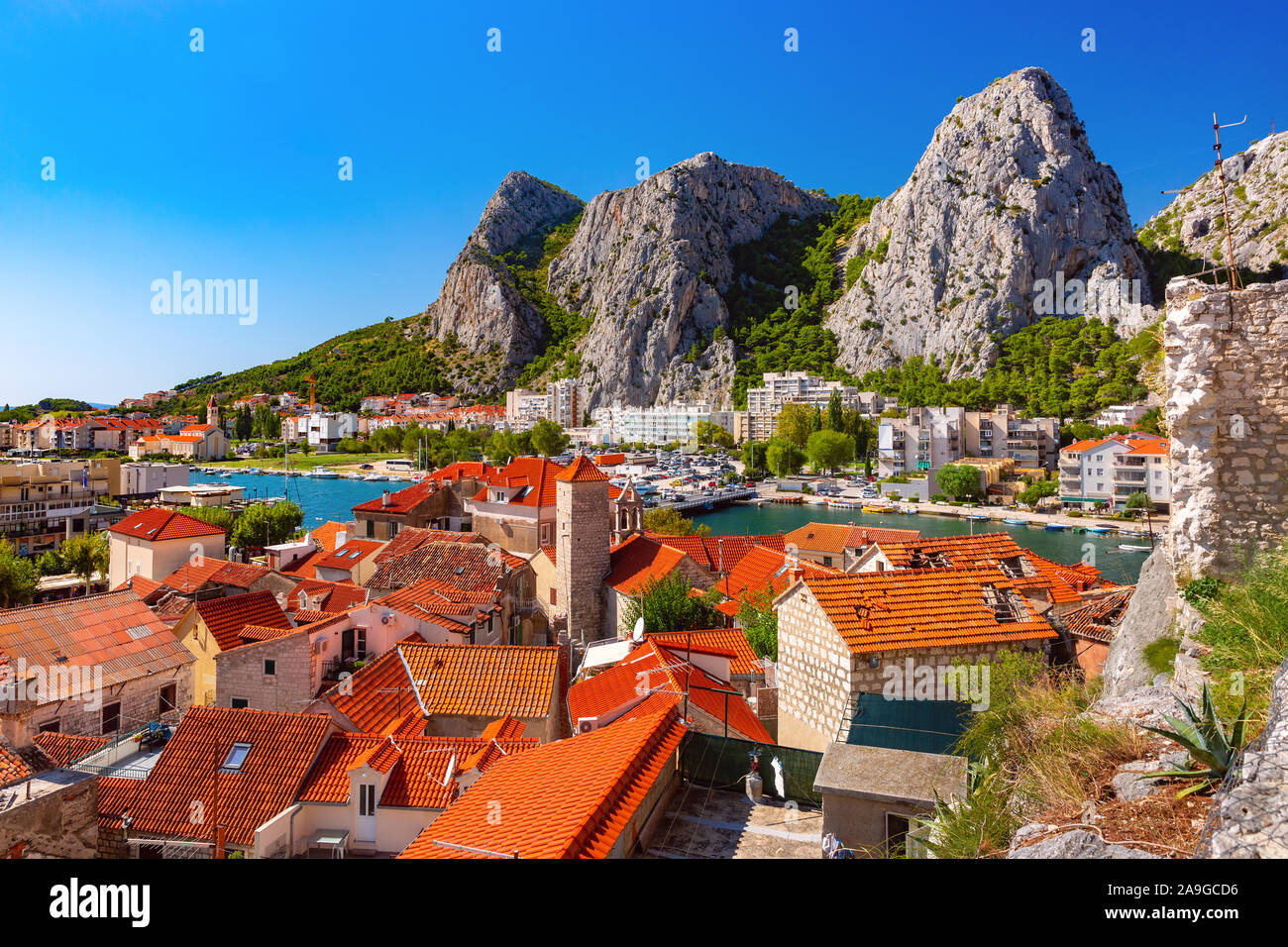 Sunny bella vista aerea del fiume Cetina, le montagne e i tetti della città vecchia in Omis, molto popolare meta turistica in Croazia Foto Stock