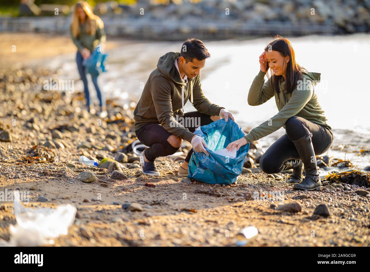 Team di volontari raccogliere rifiuti in spiaggia Foto Stock