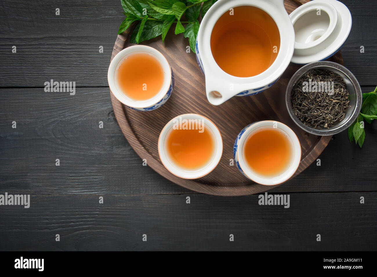 La cerimonia del tè. Tazze di tè verde con menta e bollitore su sfondo scuro. Concetto cinese. Vista da sopra. Asian ancora in vita. Foto Stock