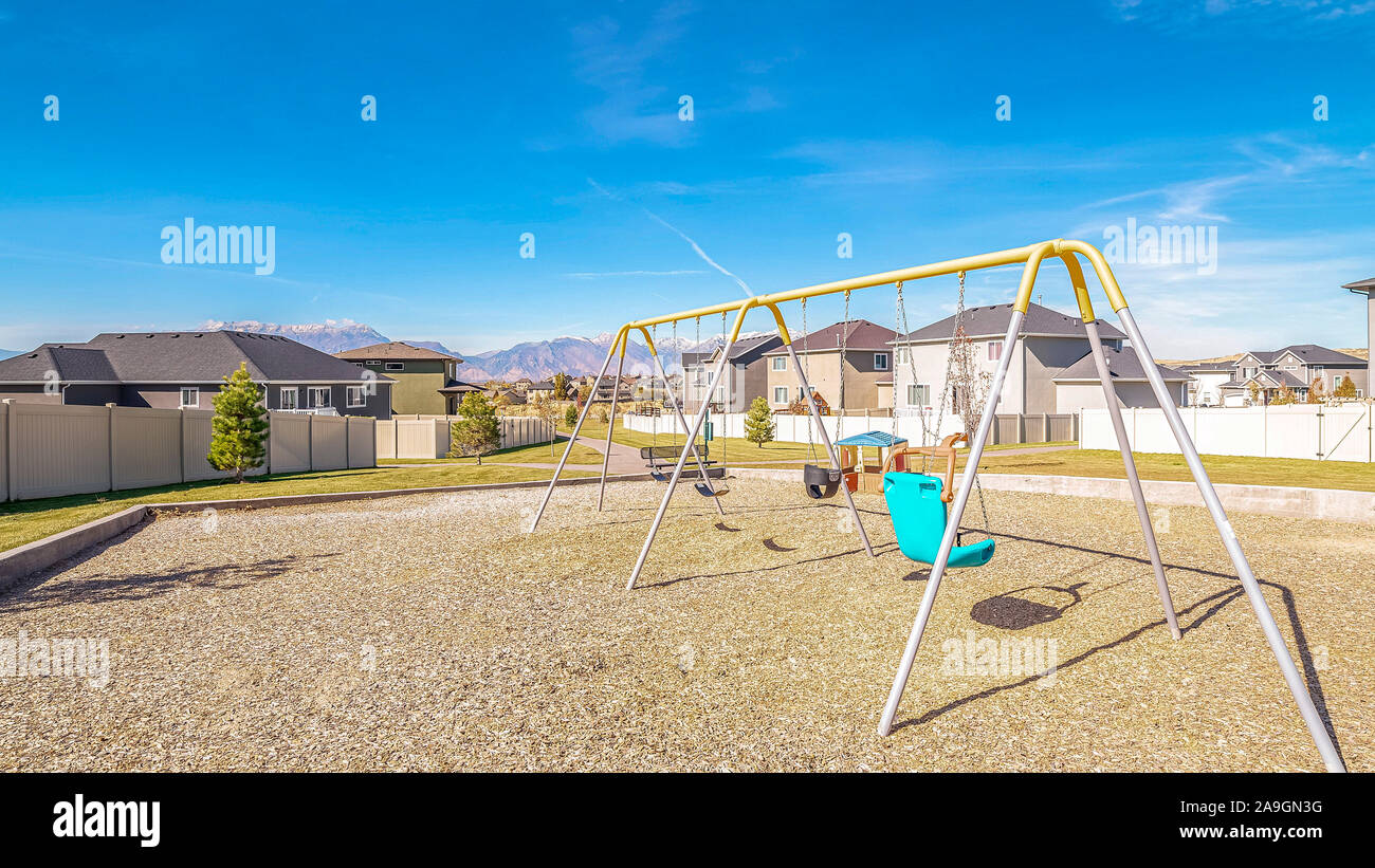 Panorama Un-cornice oscilla in un parco giochi per bambini durante il giorno Foto Stock