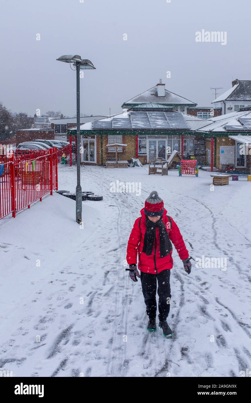 Cheam ,Surrey, Regno Unito, scuola primaria ragazzo che abbandona la scuola nella neve Foto Stock