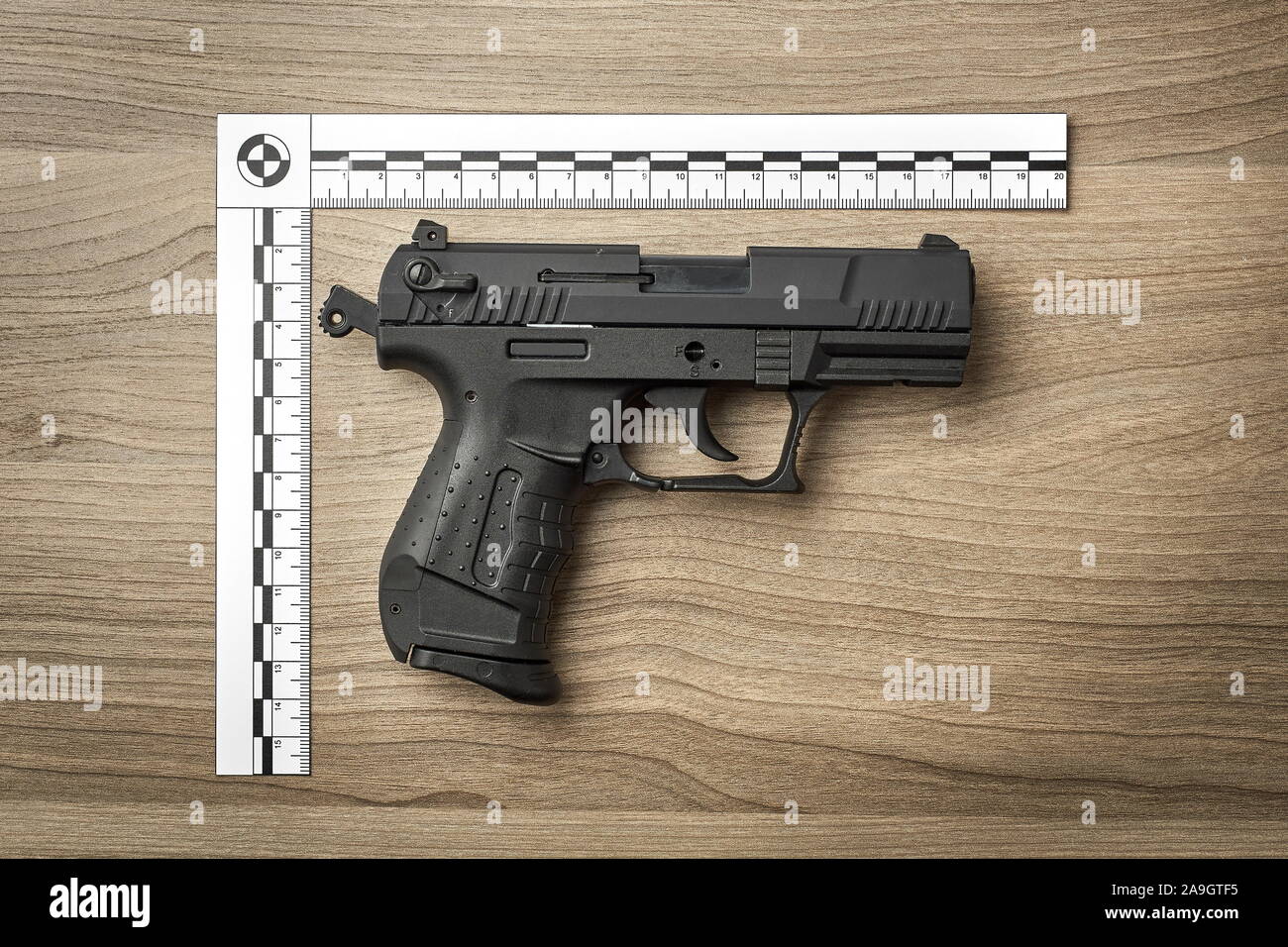 Crime Scene Investigation - pistola come un pezzo di prova posto con righello forense per la documentazione Foto Stock