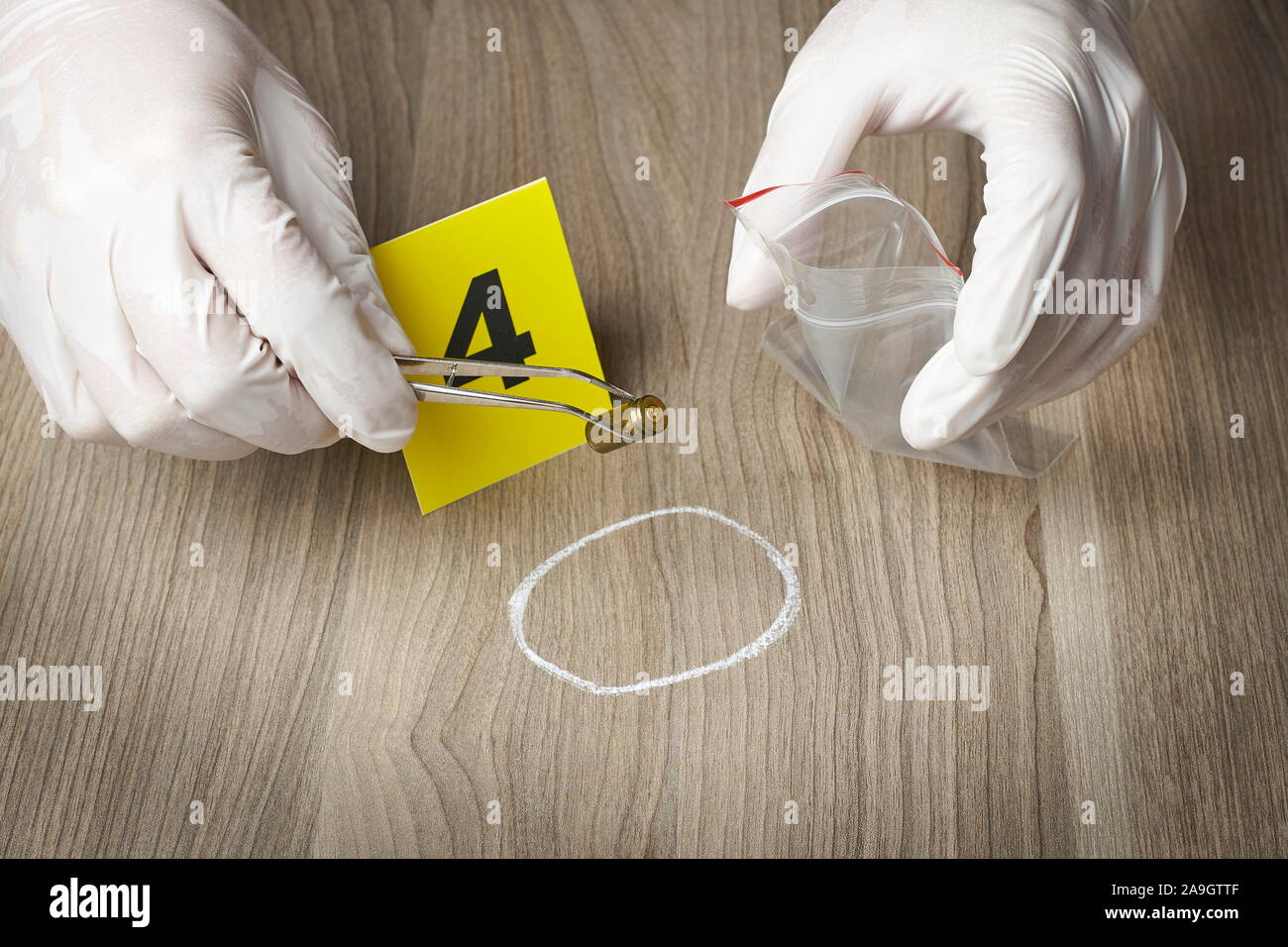 Forensic officer raccogliendo un bullet involucro come un pezzo di prova Foto Stock