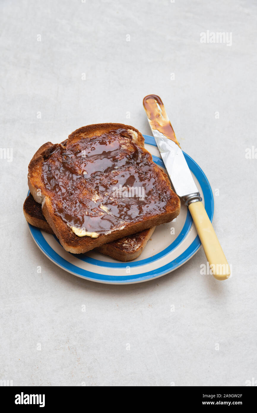 Marmite su pane tostato su una piastra su sfondo bianco Foto Stock