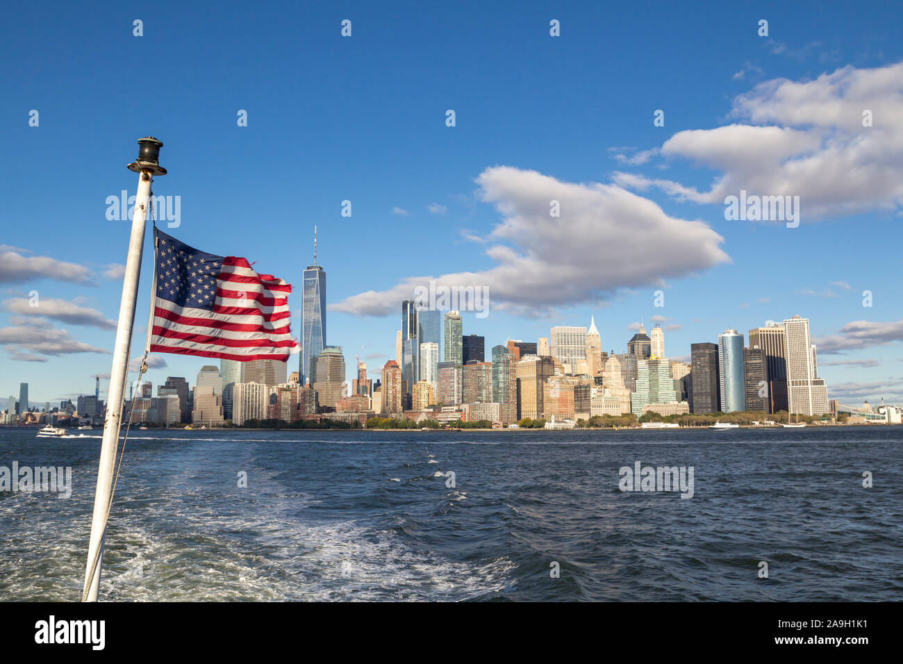 New York inferiore dello skyline di Manhattan con one world trade center, con una bandiera americana Foto Stock