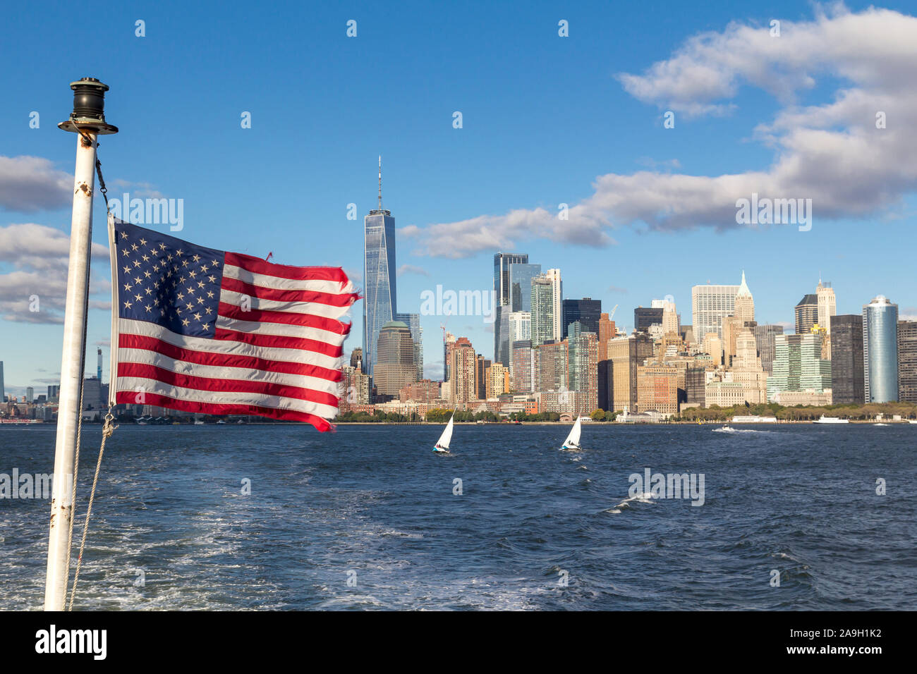 New York inferiore dello skyline di Manhattan con one world trade center, con una bandiera americana Foto Stock