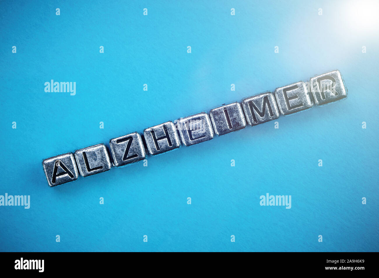 La malattia di Alzheimer il concetto di sfondo rappresentato da cubi lettere in metallo Foto Stock