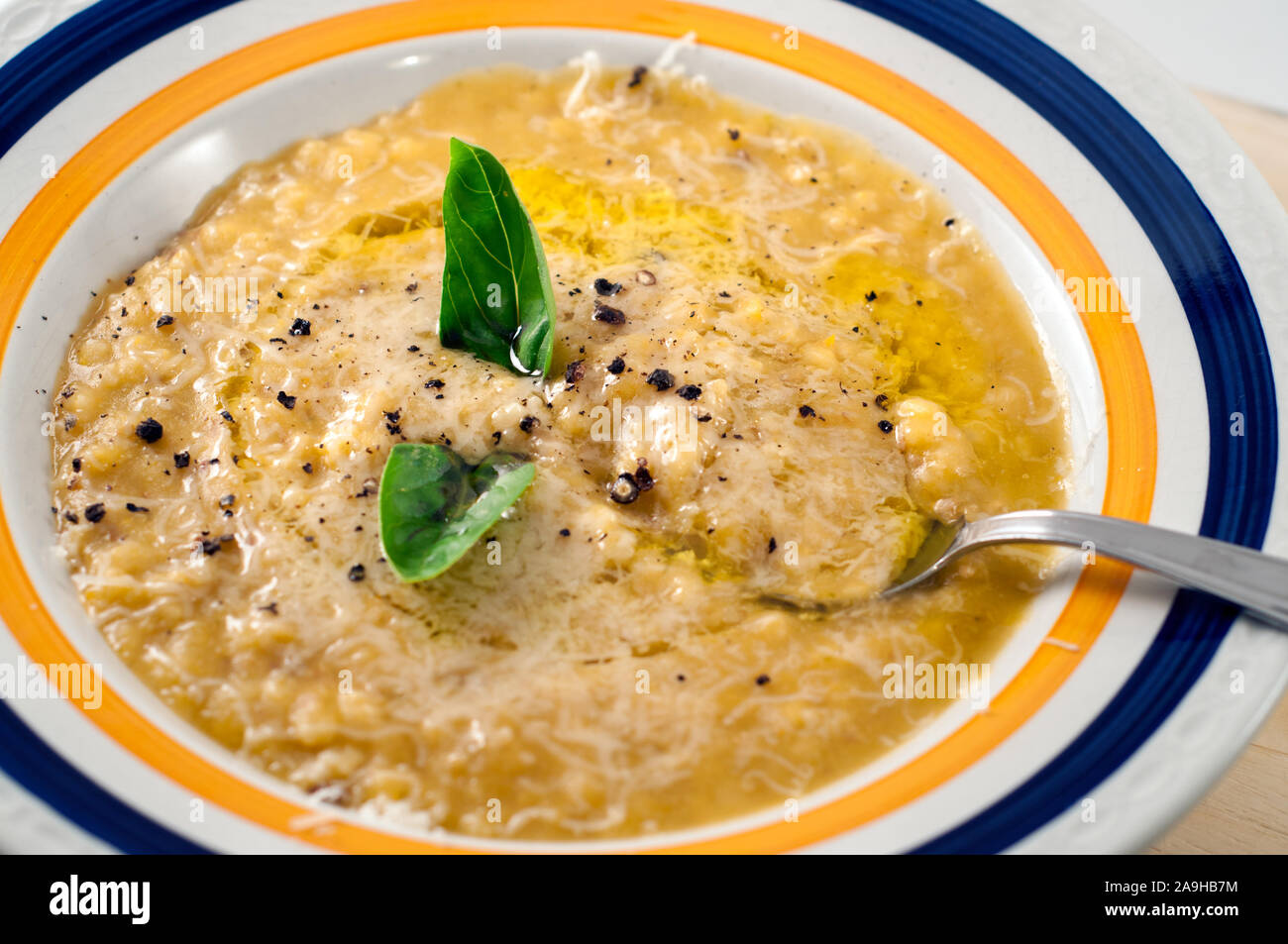 Chiudere ap di una zuppa di zucca con riso,l'olio d'oliva, il formaggio parmigiano , pepe e basilico. Uno stile di vita sano, Foto Stock