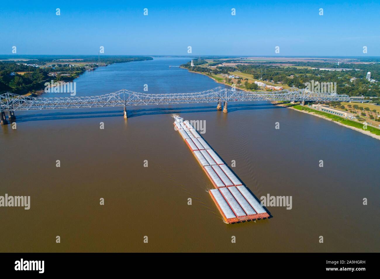 Barge trasporta merci fino il fiume Mississippi in natchez con ponte in background Foto Stock