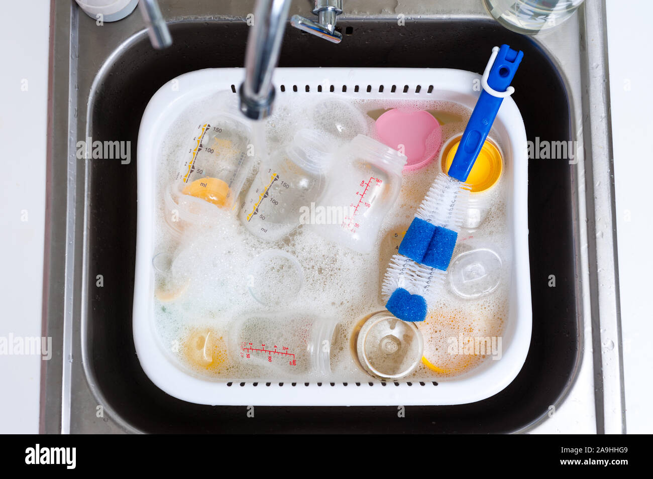 Il lavaggio di biberon e tettarelle con bottiglia Morbido pennello e detersivo liquido per stoviglie Foto Stock