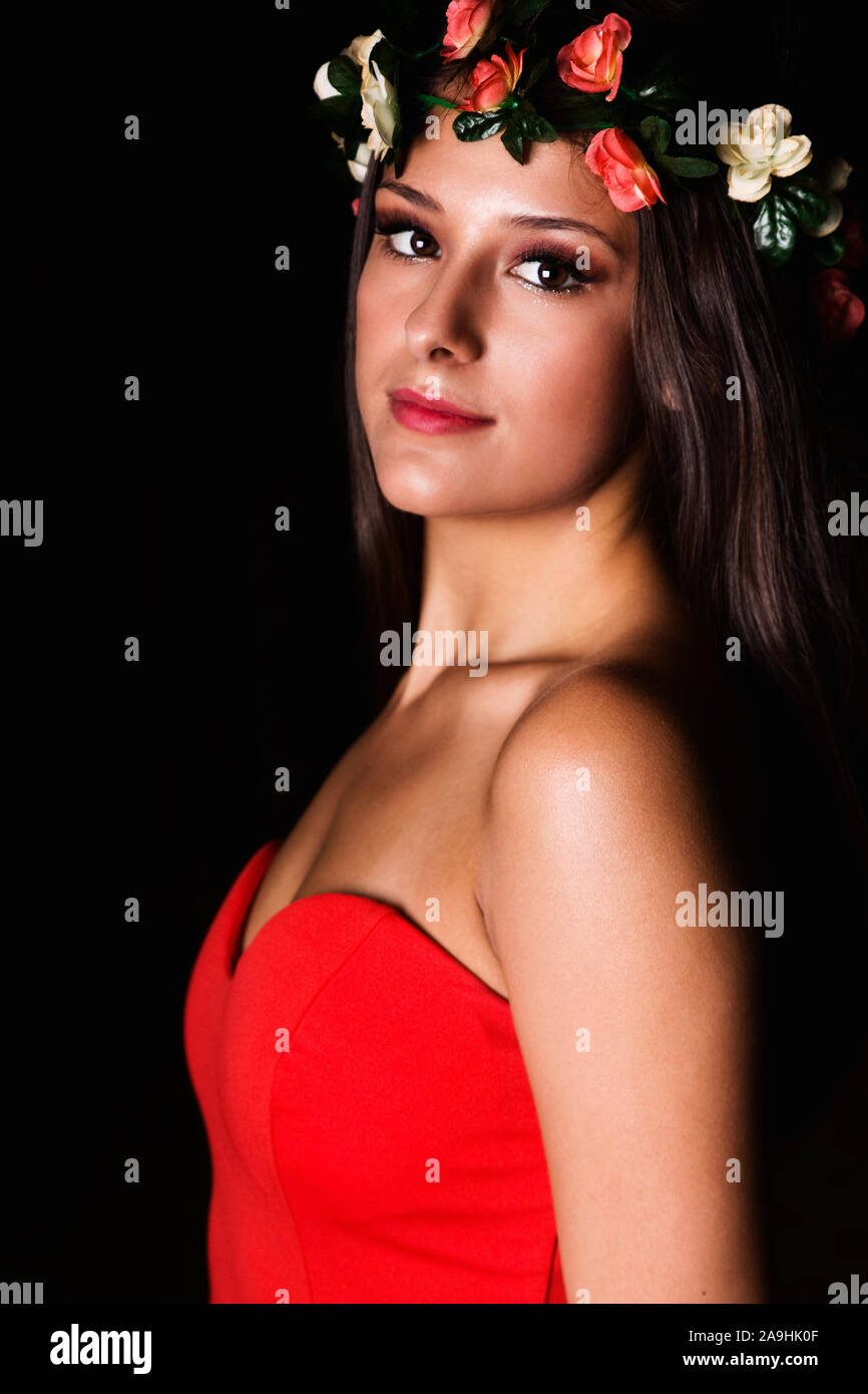 Outdoor di alta moda foto di donna in un rosso abito da sera con un omaggio floreale il pezzo di testa Foto Stock