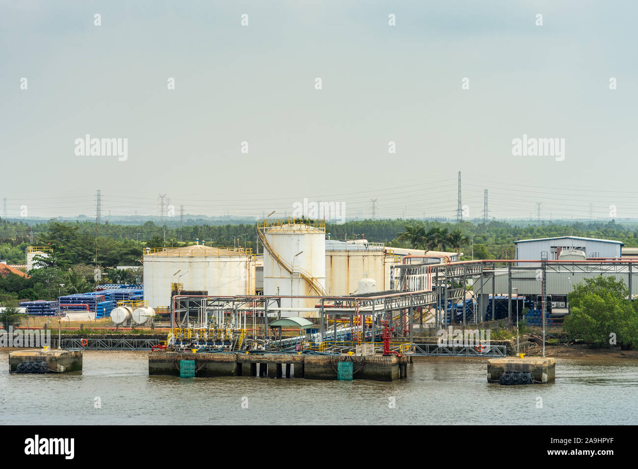 Lungo il fiume Tau, Vietnam - Marzo 12, 2019: Phuoc Khanh area. PetroVietnam in e out installazione di pompaggio in cui le navi sono gestite. Serbatoi di bianco e gree Foto Stock