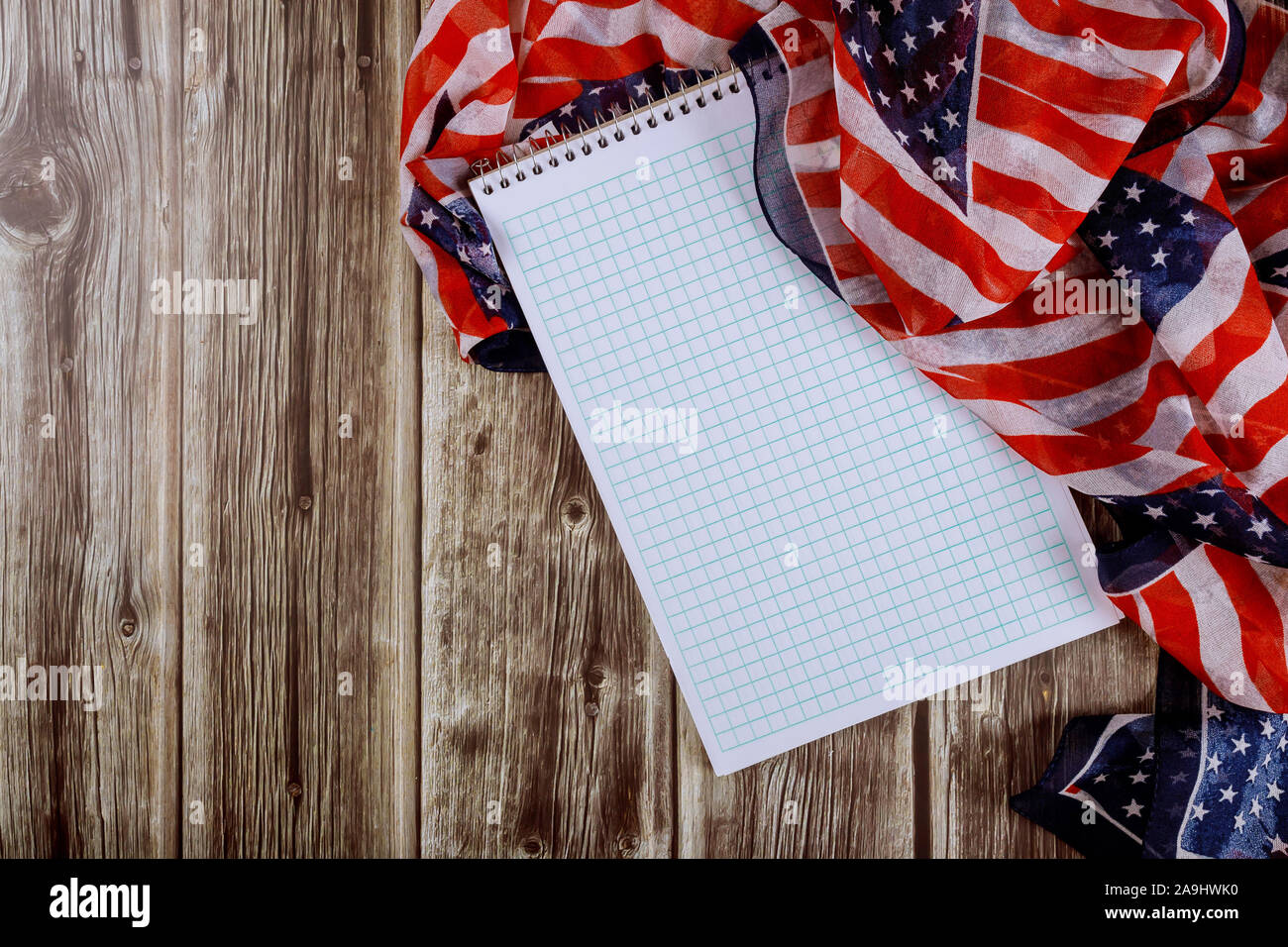 Splendidamente sventolano strisce stelle della bandiera americana con notebook su tavola in legno per lo sfondo Foto Stock