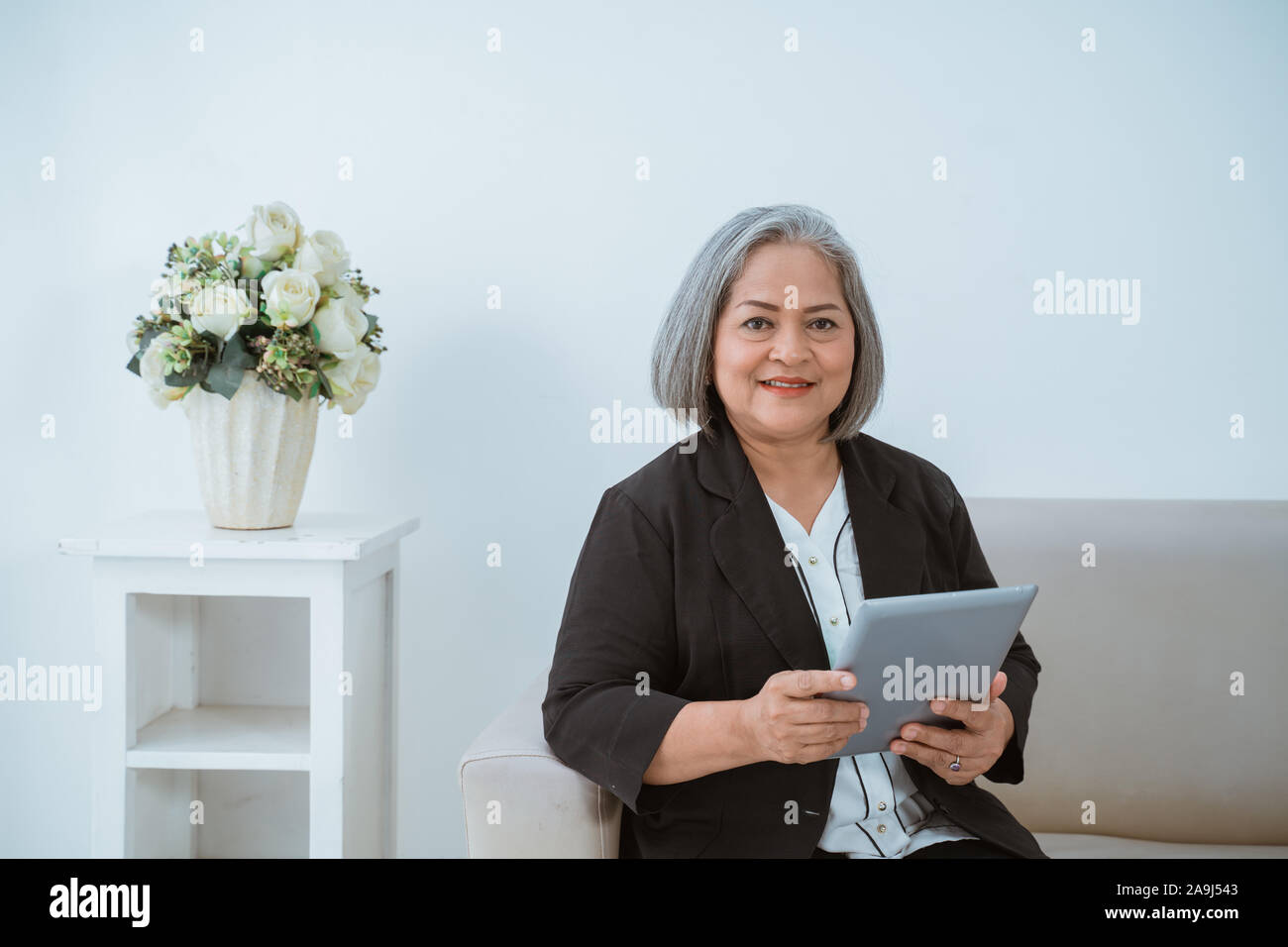 Fiducioso vecchia donna casualmente gestisce la sua azienda Foto Stock