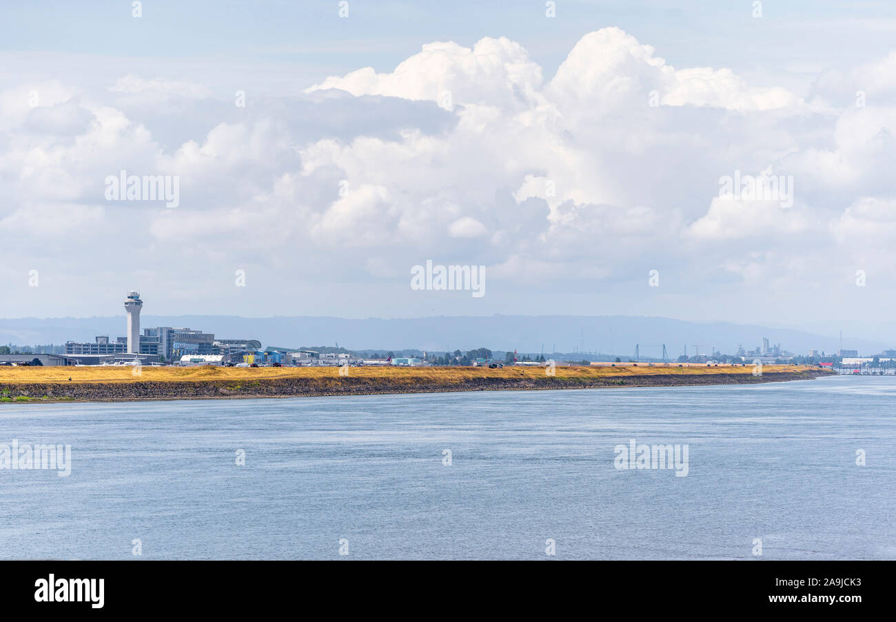 Nascosti in autunno di haze streak di erba ingiallito sulle rive del fiume Columbia e Portland Airport con una torre di controllo sporgenti verso il cielo Foto Stock