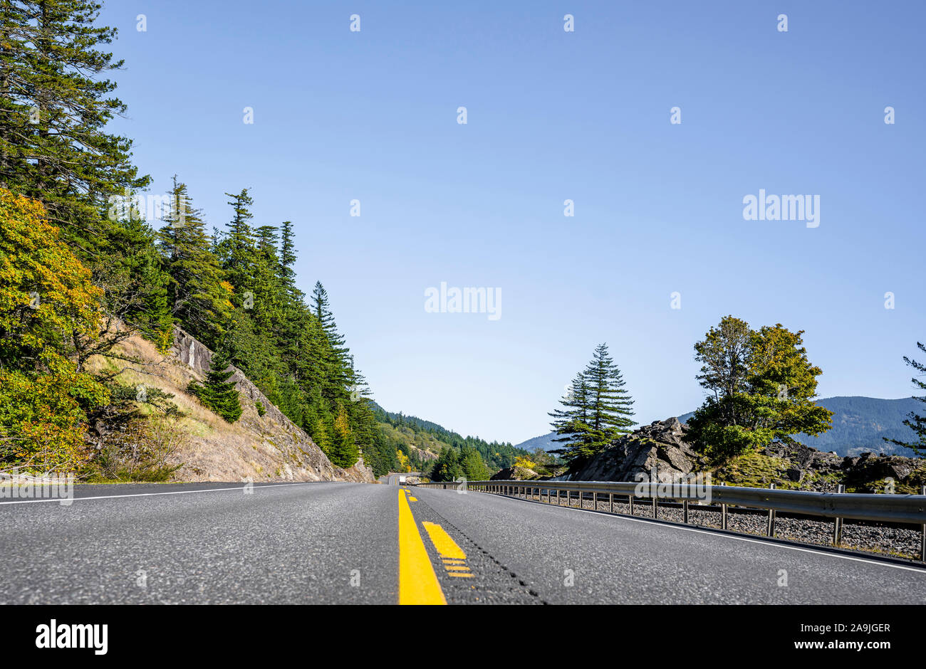 Un incantevole paesaggio che attrae i turisti con una tortuosa strada con cartello stradale attorno ad una roccia su un lato e un abisso sull'altro lato in th Foto Stock