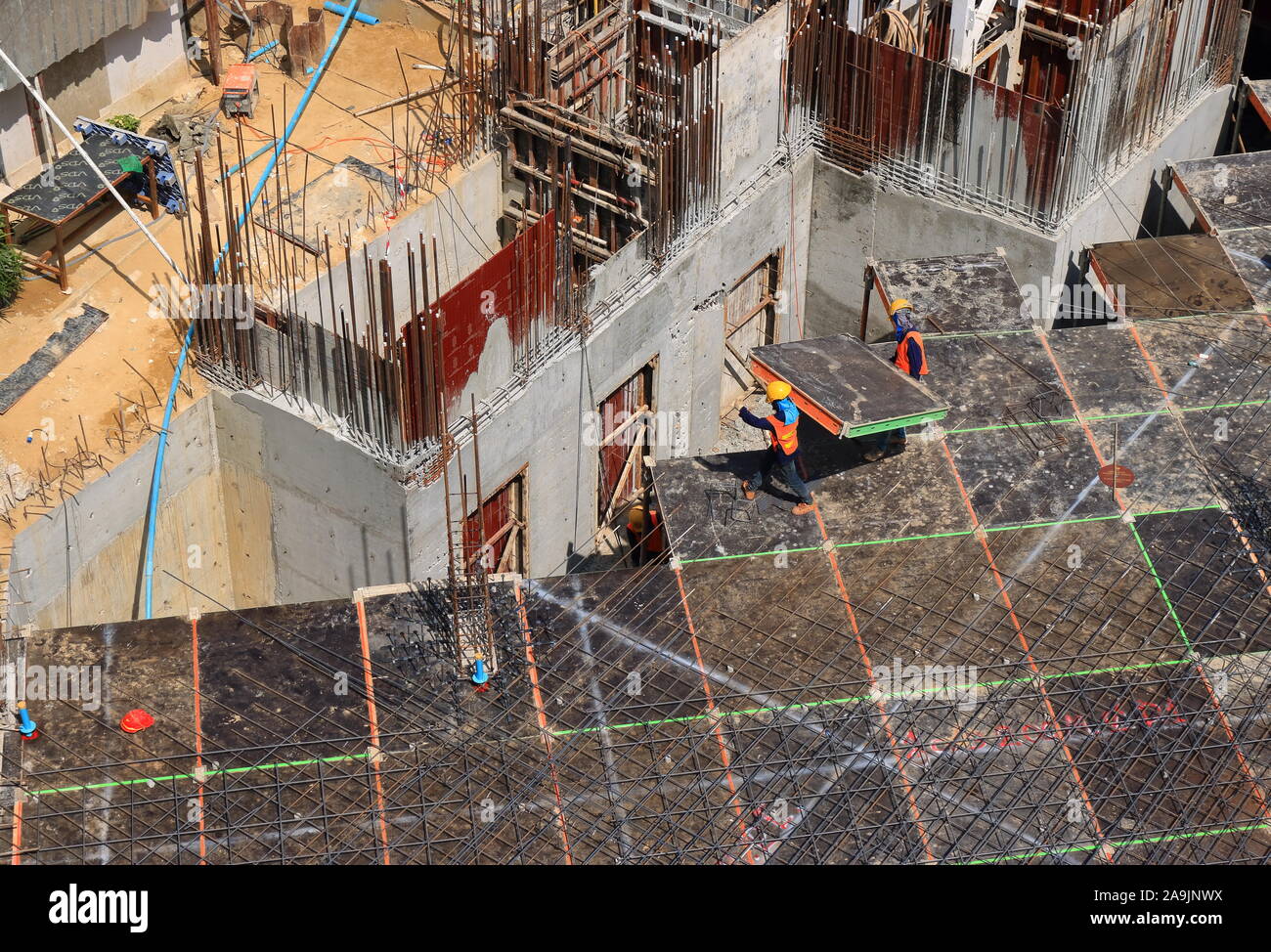 Bangkok, Tailandia - 16 Novembre 2019 : due lavoratori indossano uniformi e caschi sono portanti prefabbricati in lastra di calcestruzzo mentre si lavora al sito in costruzione Foto Stock