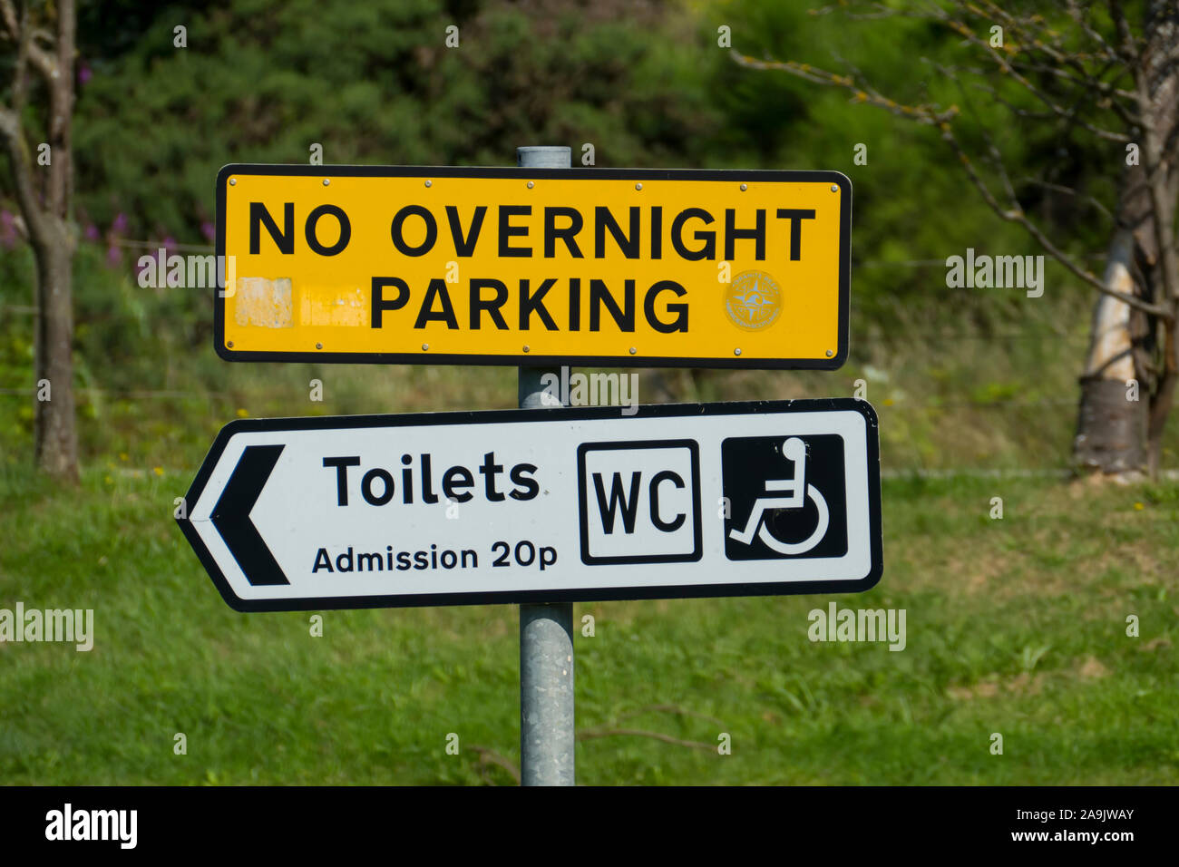 Schild auf einem öffentlichen Parkplatz mit dem englischen testo No parcheggio notturno, bagni, ingresso 20p, WC Foto Stock