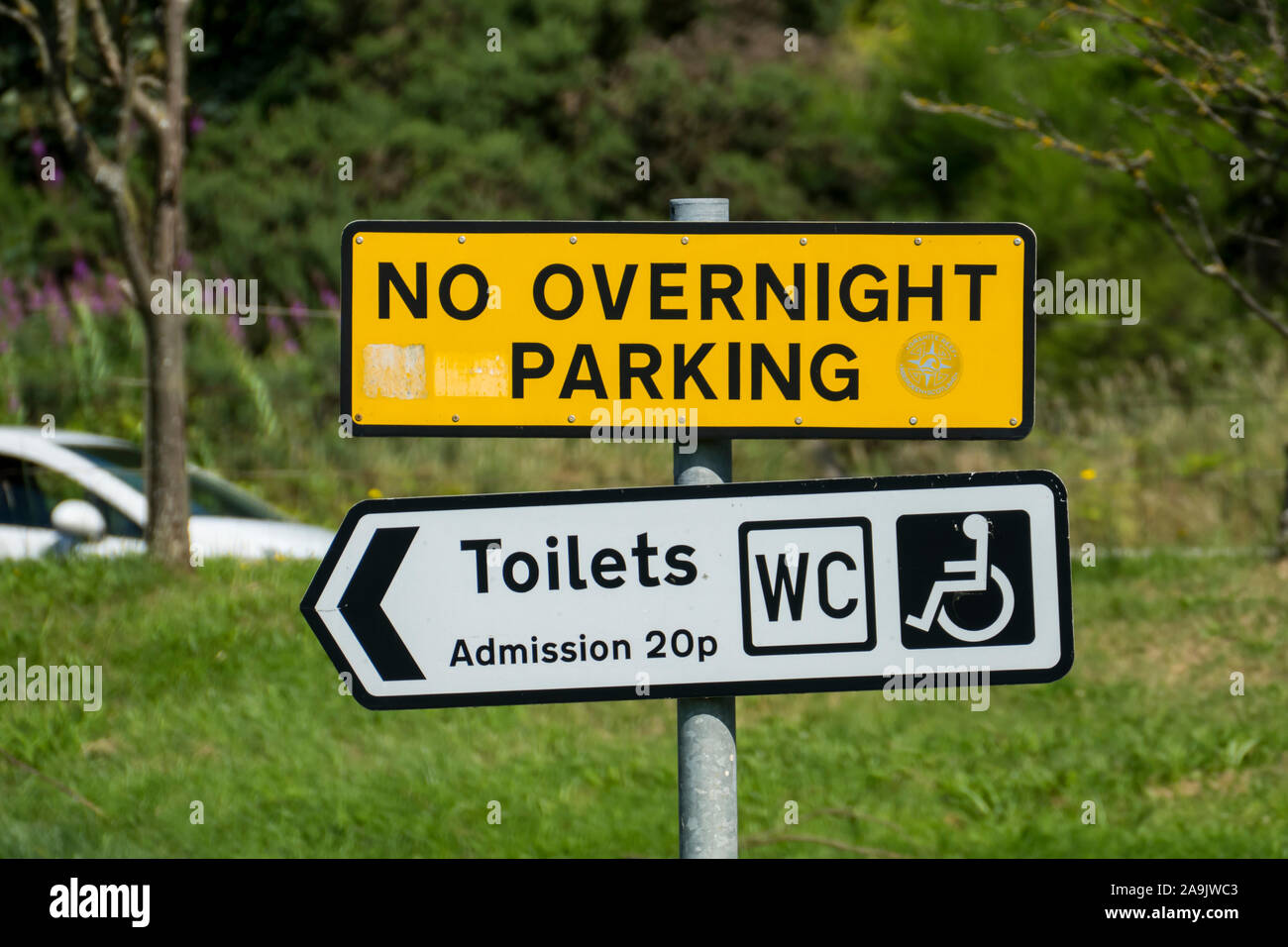 Schild auf einem öffentlichen Parkplatz mit dem englischen testo No parcheggio notturno, bagni, ingresso 20p, WC Foto Stock