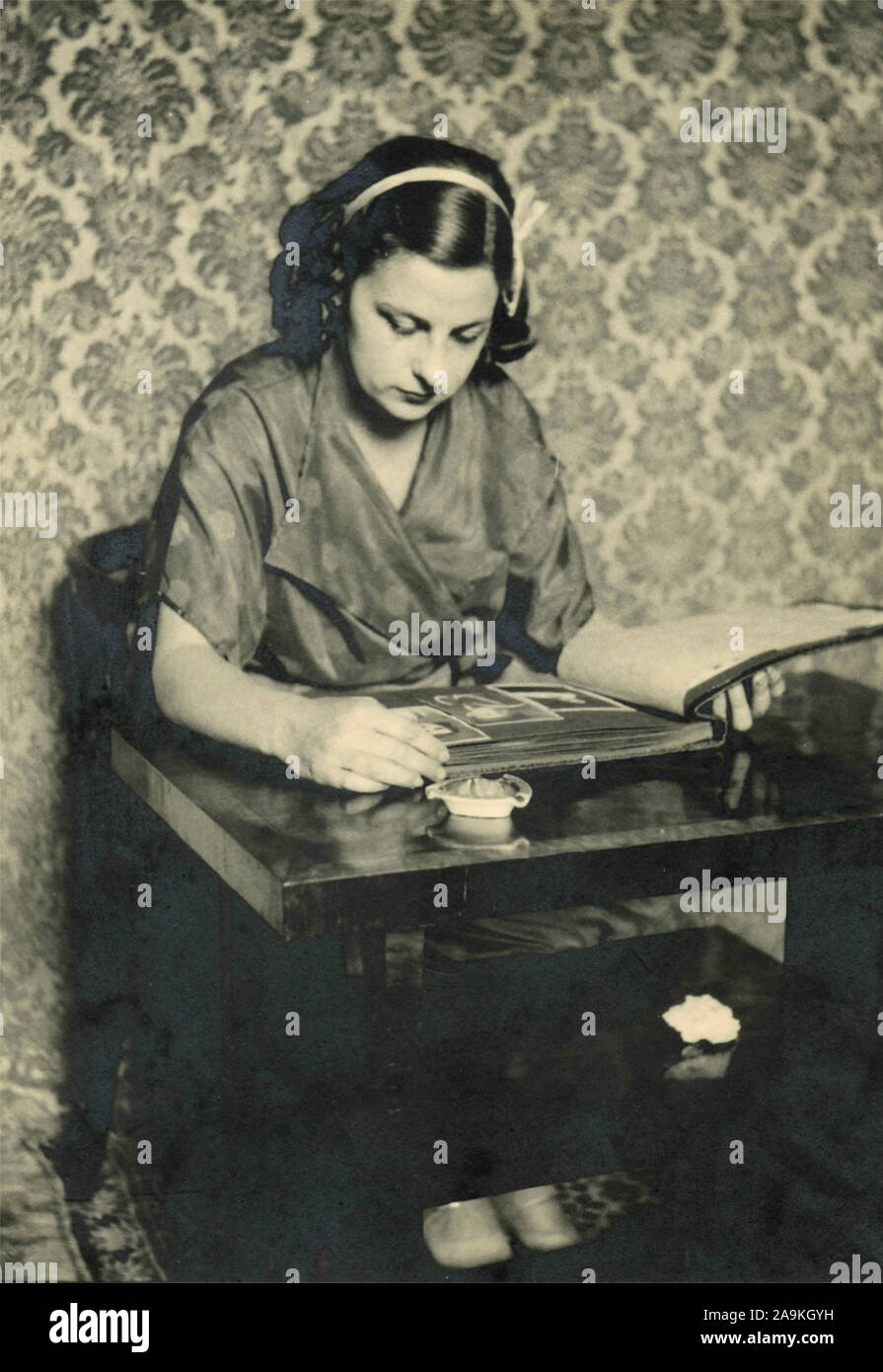 Una donna che guarda attraverso un album di vecchie fotografie, Italia Foto Stock