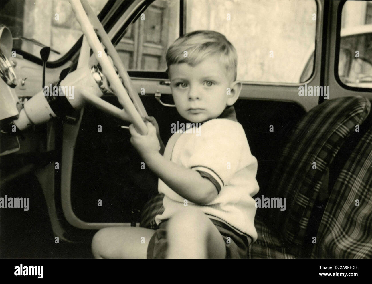 Un bambino si siede dietro al volante di una vettura, Italia Foto Stock