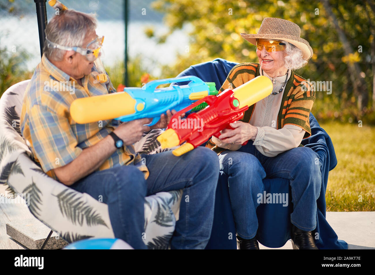 Crazy Senior l uomo e la donna.felice coppia senior in vacanza giocando con la pistola ad acqua. Foto Stock