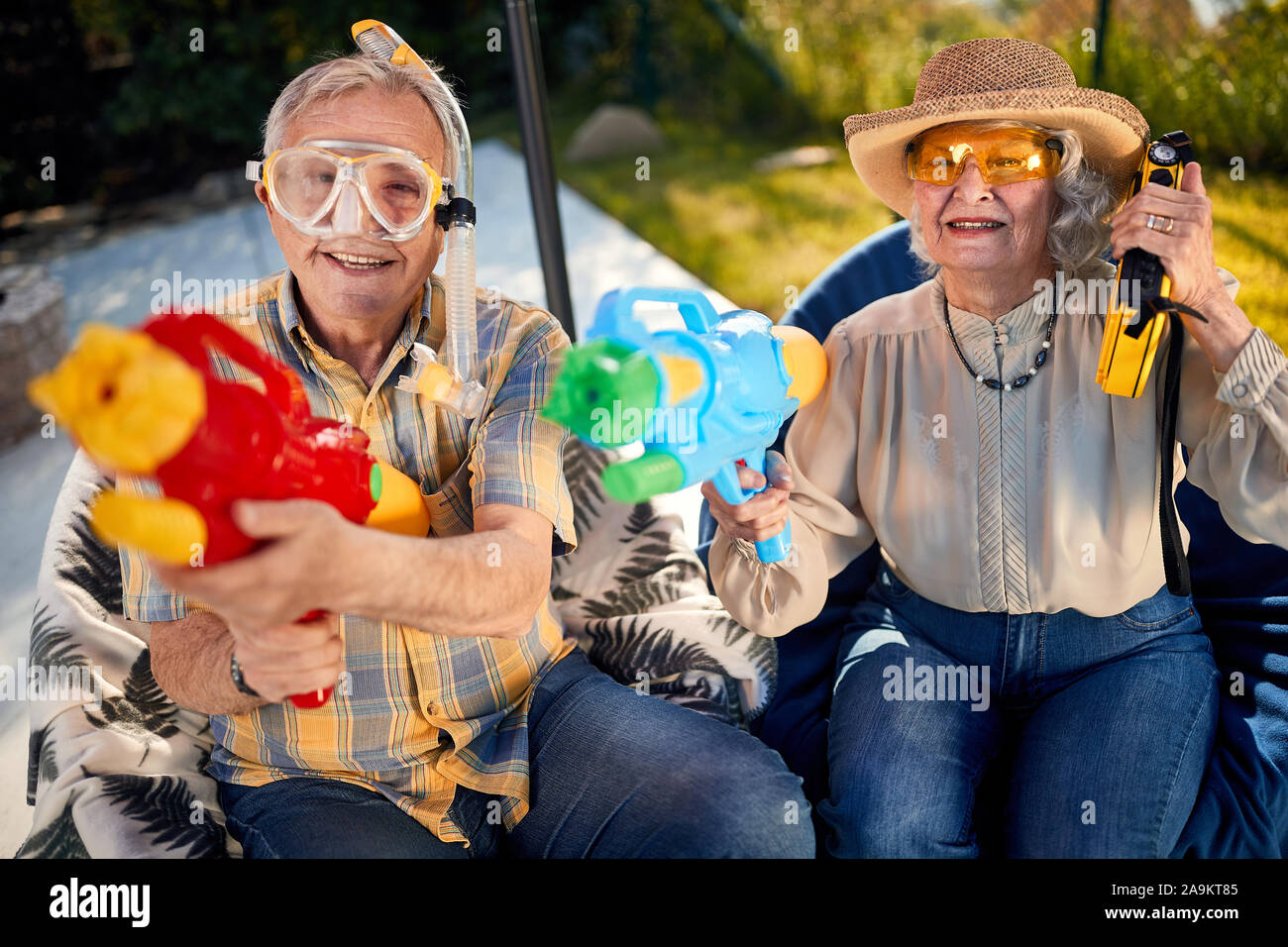 Crazy old felici le persone a divertirsi in vacanza giocando con la pistola ad acqua Foto Stock