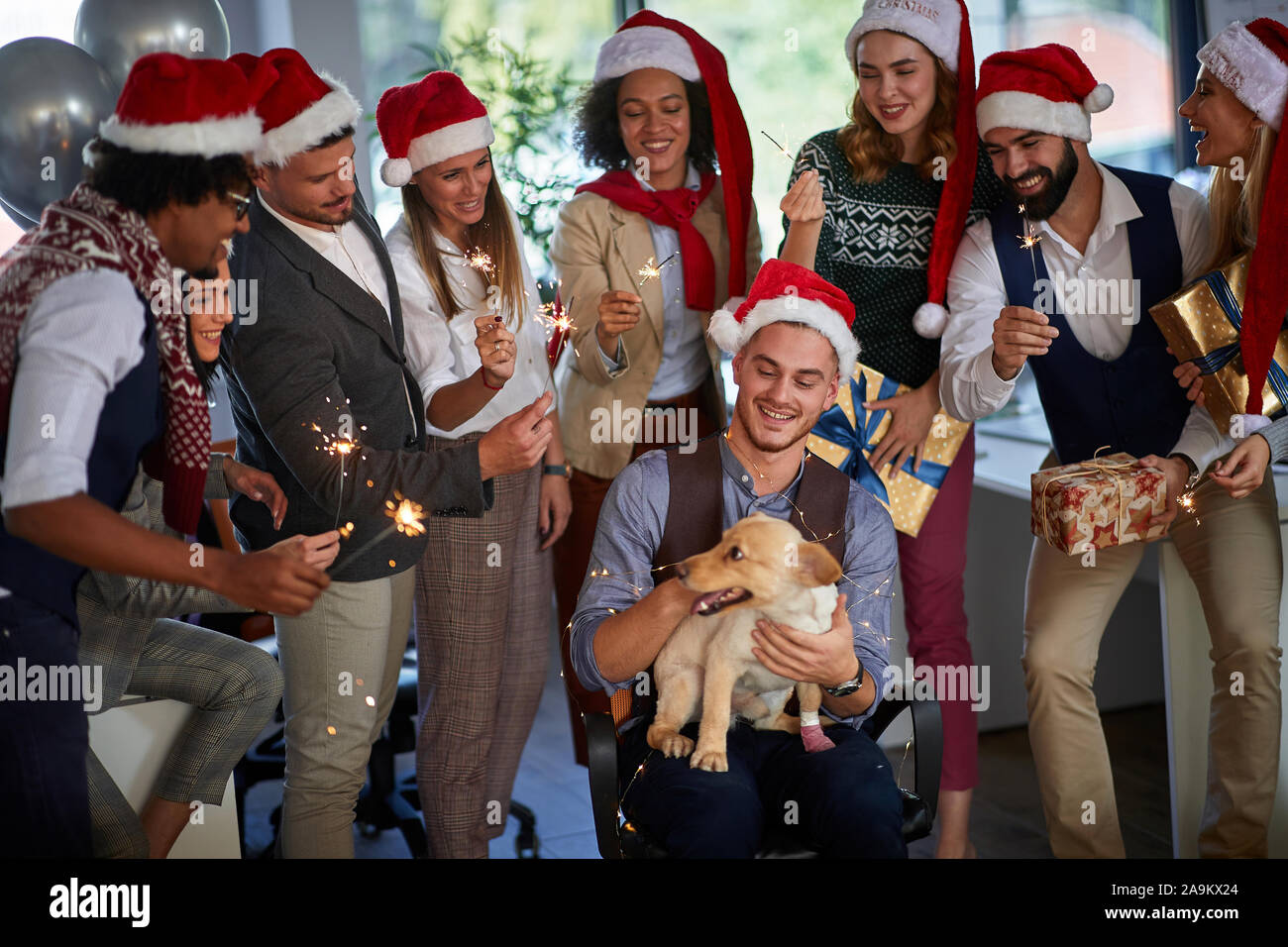 I lavoratori festeggiano il Natale insieme al lavoro.felice la gente di affari in santa con cappello di Natale presente. Foto Stock