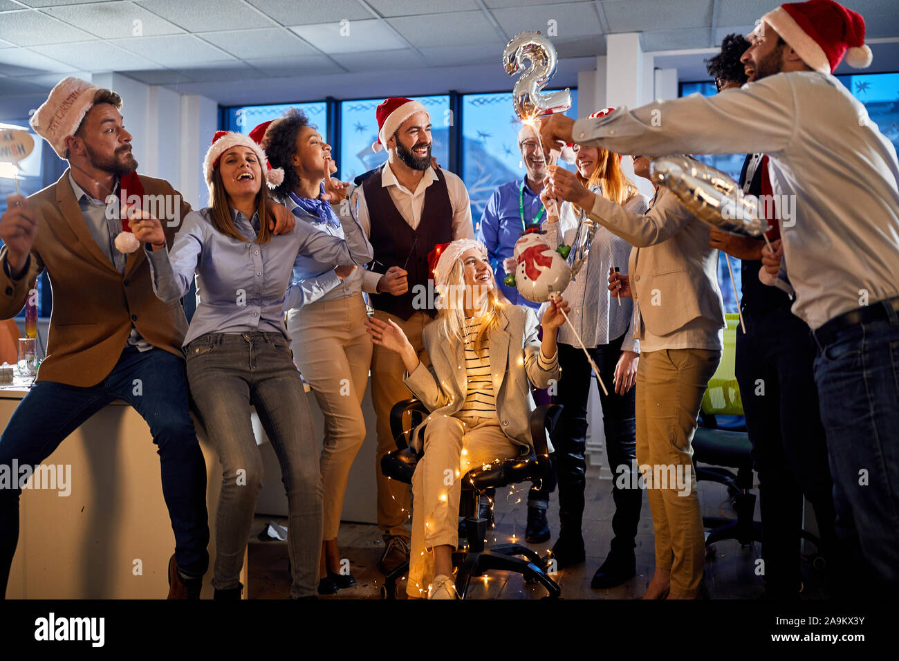 Felice giovane gente di affari in cappelli di Babbo Natale celebrare la vacanza al lavoro.Buon Natale e Felice Anno Nuovo Foto Stock