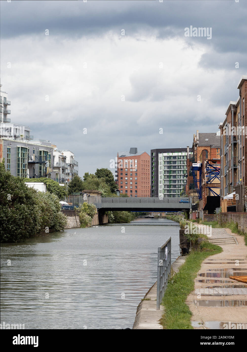 Vista lungo il Limehouse tagliare canal con nuovi sviluppi residenziali in un post-zona industriale (Limehouse, Londra, Regno Unito). Dopo la pioggia. Foto Stock