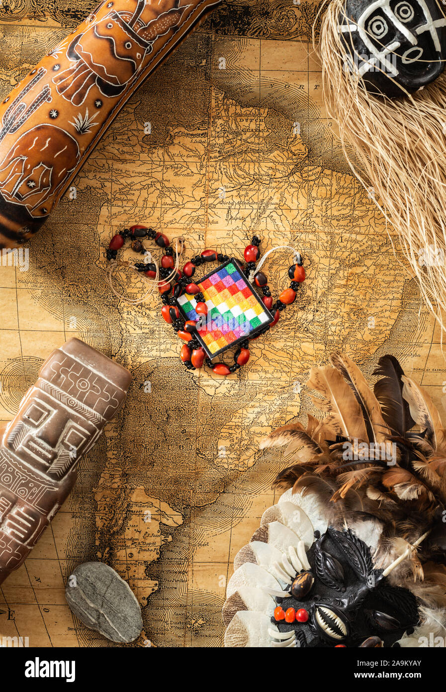 Una bandiera indiana su una vecchia mappa coloniale del Sud America lungo con tradizionale artigianato indiano da tutto il continente Foto Stock