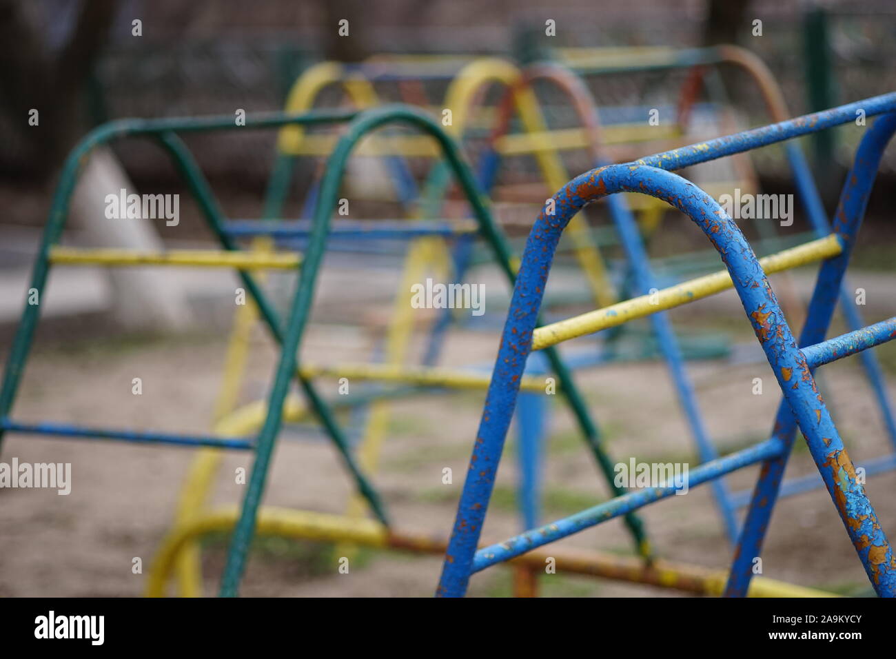 Attrezzature per parchi giochi. Scala in ferro per i giochi dei bambini con peeling vernice. Vecchia scuola materna di giorno nuvoloso Foto Stock