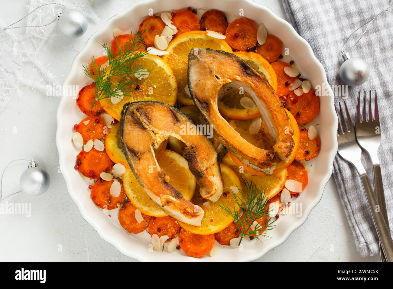 Carpa fritta dei tranci di pesce con carota e arance. Tradizionale polacco della vigilia di Natale piatto. Foto Stock