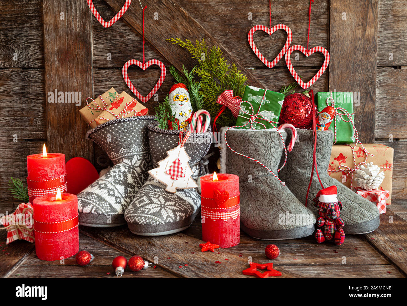 Stivali in maglia con piccoli regali e caramelle per Natale Foto Stock