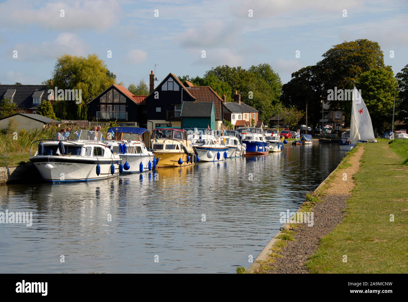 Thurne dyke, un piccolo taglio del fiume Thurne al villaggio Thurne, Norfolk, Inghilterra, con diversi incrociatori ormeggiati Foto Stock