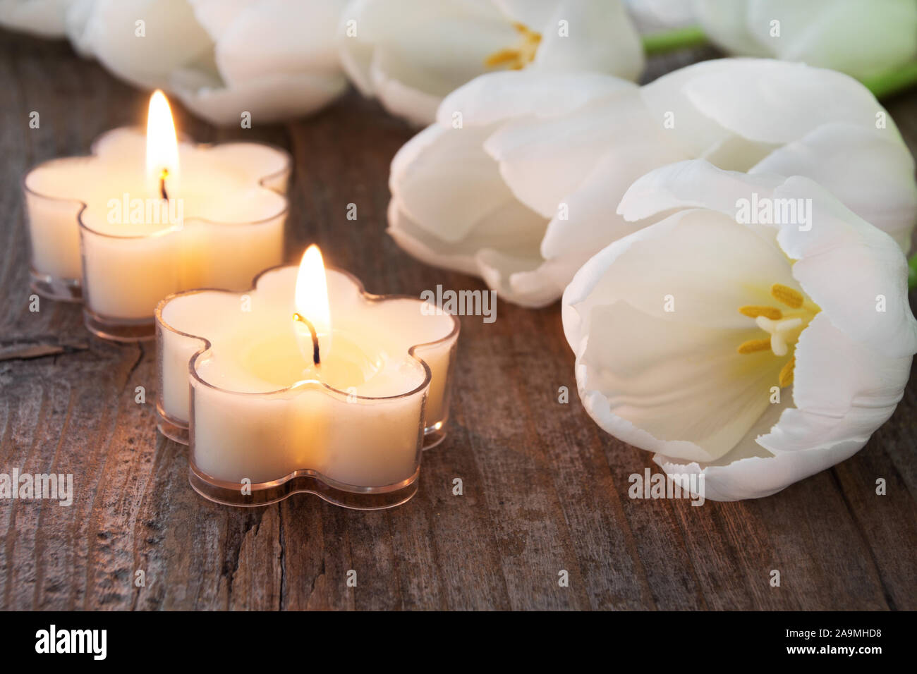 Decorazione di pasqua candele con tulipani bianco su uno sfondo di legno Foto Stock