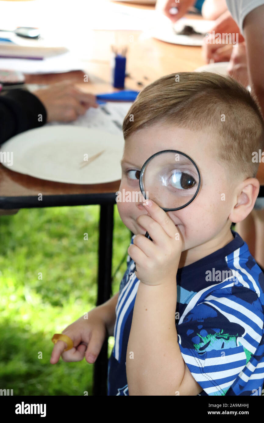 Ragazzo indagando con lente di ingrandimento Foto Stock
