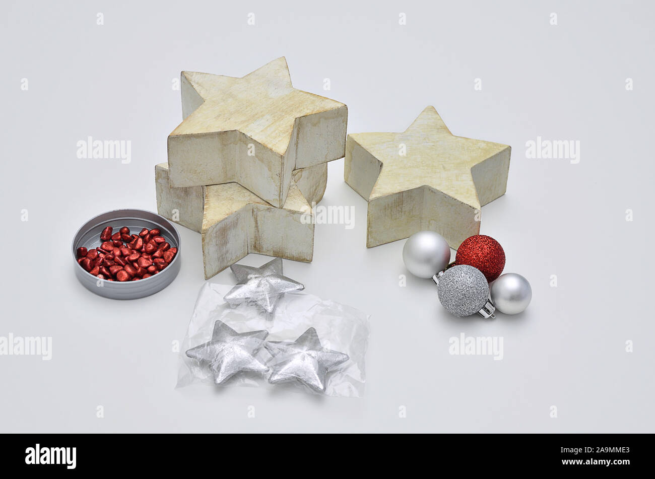 Tre grandi stelle in legno con rosso e argento decorazioni di Natale, vicino, isolati su sfondo bianco Foto Stock