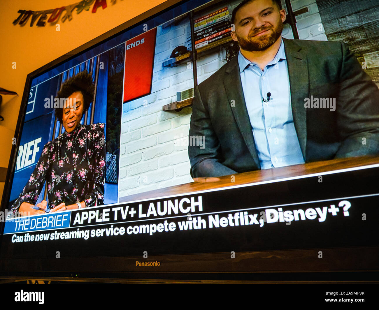 Parigi, Francia - 1 Nov 2019: Uomo con telecomando a guardare le ultime notizie con Apple TV plus lancio - filmato streaming service dal computer Apple competere con Netflix, Disney Plus Foto Stock