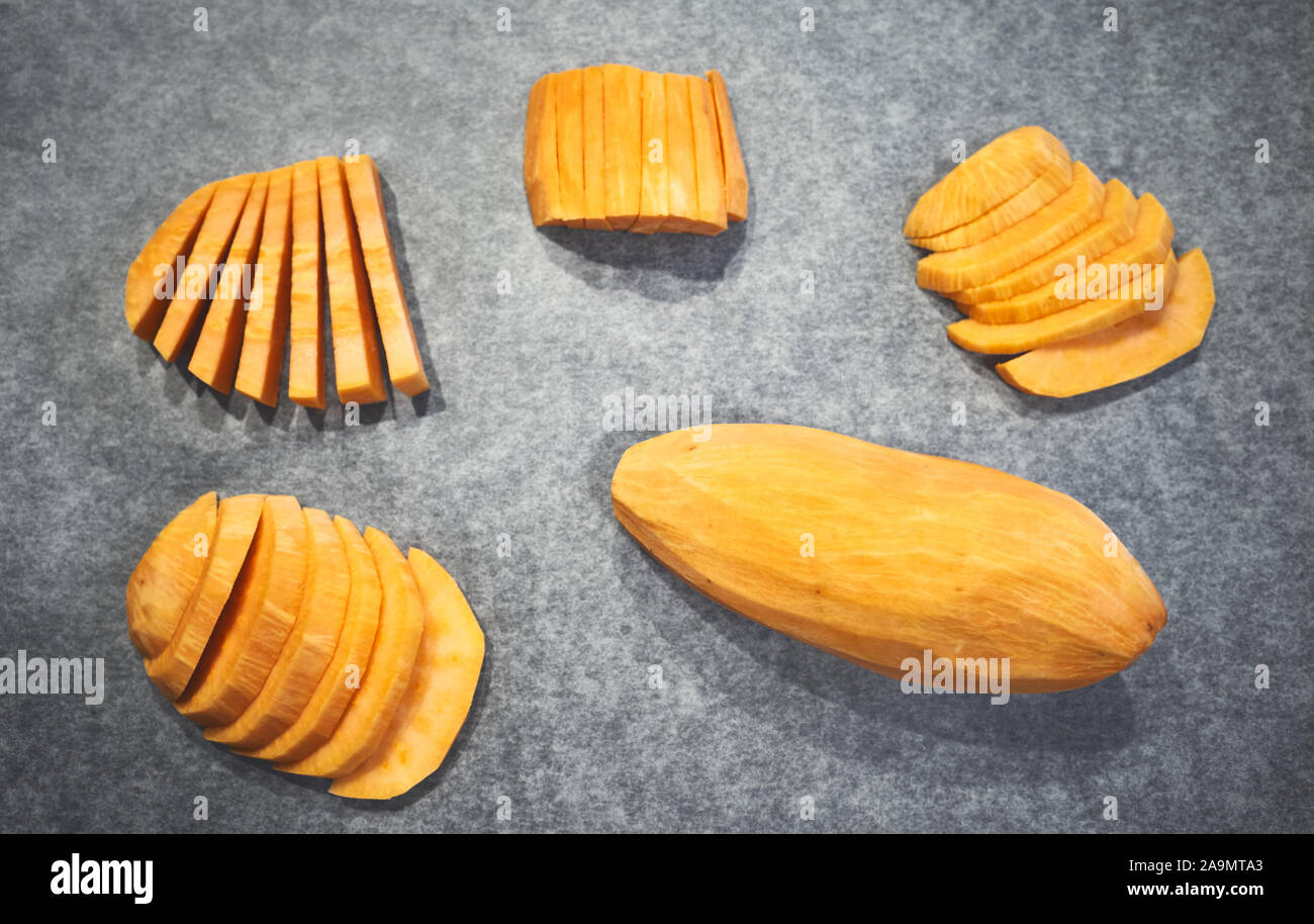 Freschi patate dolci sulla carta da forno, il fuoco selettivo. Foto Stock