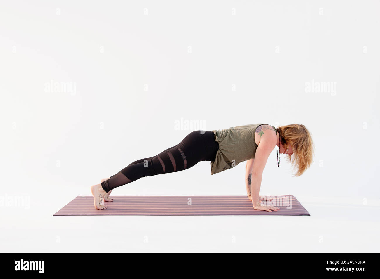 La donna a praticare Yoga asana su uno sfondo bianco. Foto Stock