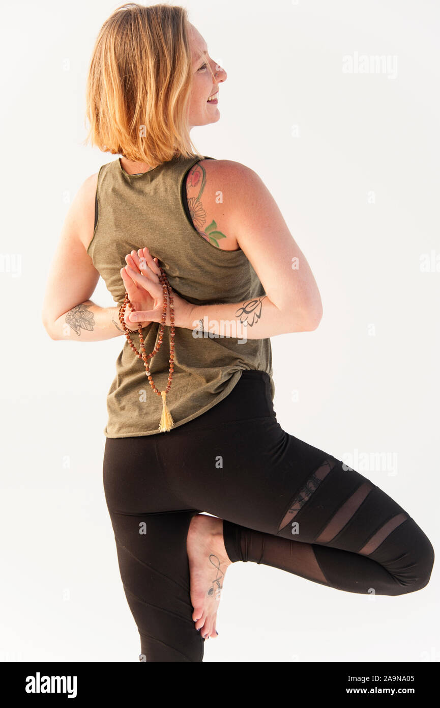 La donna a praticare Yoga asana su uno sfondo bianco. Foto Stock