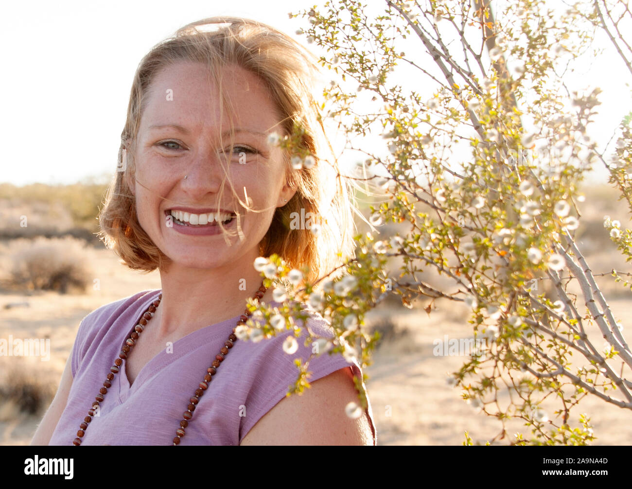 Giovane donna felice giocando lo yoga ed esprimendo fitness generale nei ritratti. Deserto Mojave Joshua Tree, CA USA Foto Stock